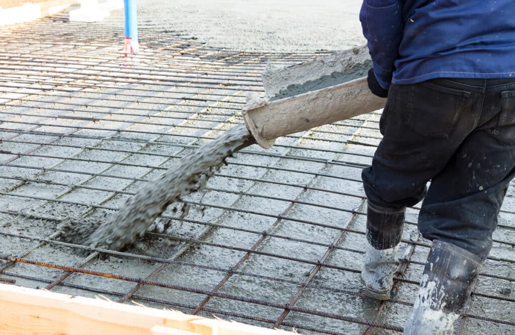 A professional laying concrete at a construction site in El Paso.